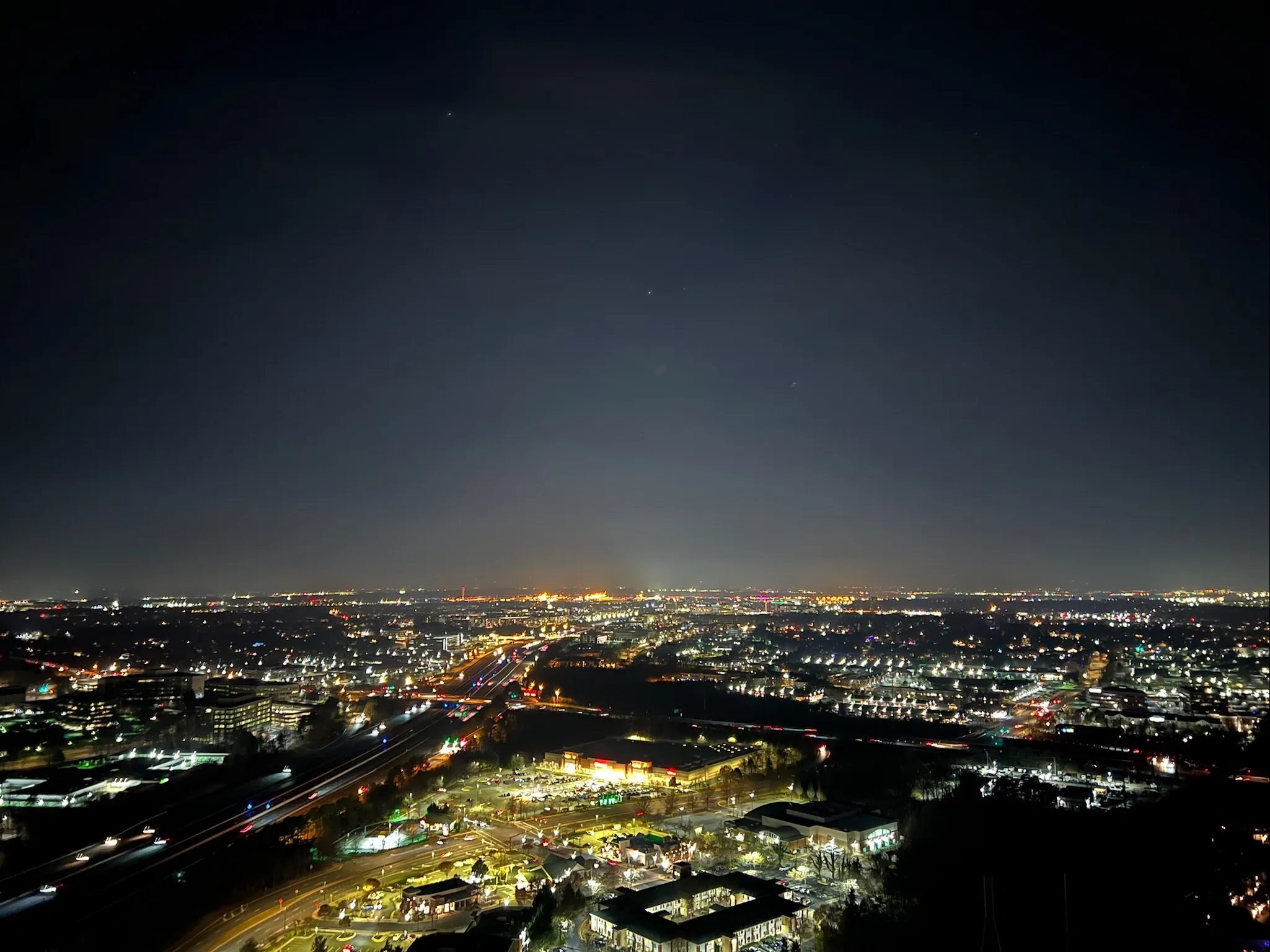 View of a dark skyline with several buildings, at night.